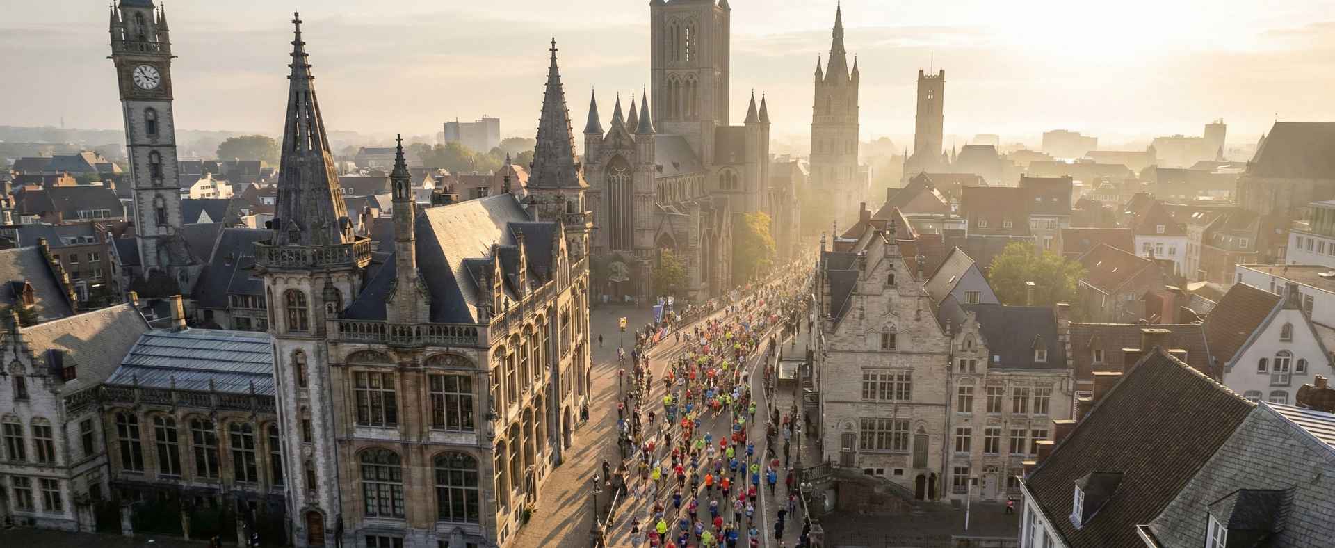 Marathonläufer auf breiter Straße durch deutsche Innenstadt bei Sonnenaufgang – Luftaufnahme eines großen Marathons in Deutschland